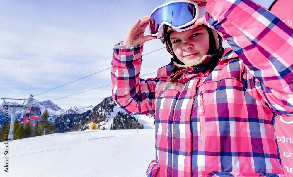 
Portrait of beautiful woman with ski and ski suit in winter mountain 
