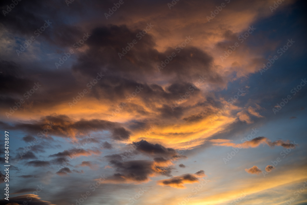 dramatic orange sky at sunset with blue cloudy sky in background