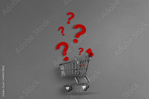 Shopping cart trolley and question mark on gray background
