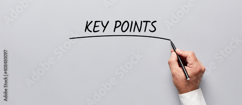 Businessman hand underlining the word key points on gray background. Highlighting the key points of an issue in business photo