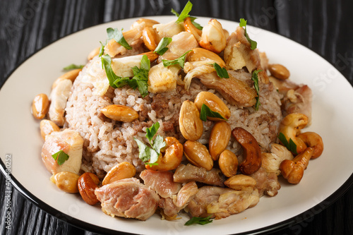 Authentic cinnamon and ground beef rice recipe topped with chicken and nuts close-up in a plate on the table. horizontal