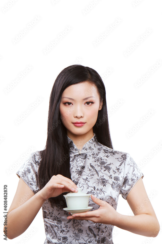 Wear cheongsam Oriental young female holding a cup of tea Wear cheongsam Oriental young female holding a cup of tea