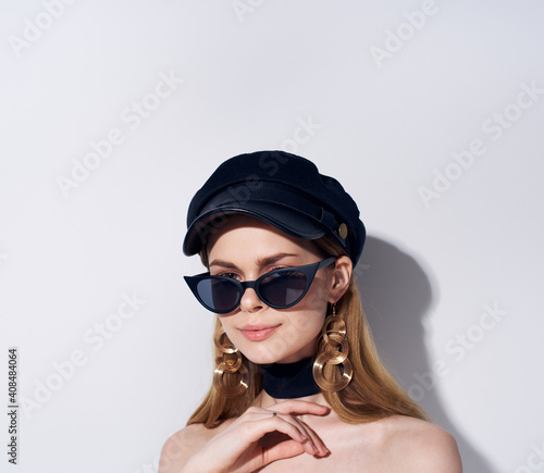 Pretty woman in black glasses bared shoulders gray background