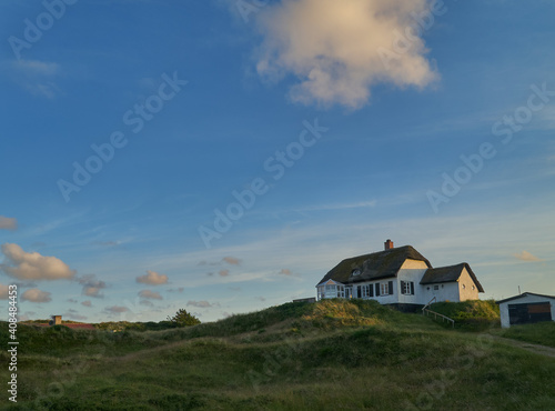 traditional rural house in the dunes of Vejers Strand (Denmark) in scenic evening sunlight