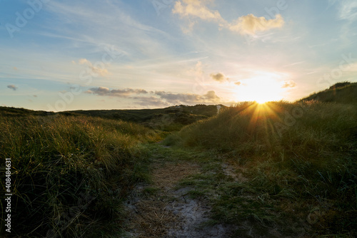 scenic sunset behind the dunes of the north sea coast in Vejers Strand (Denmark)