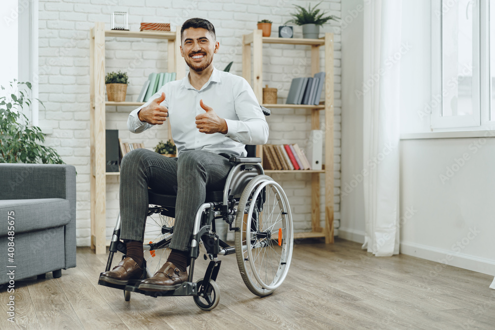 Happy smiling young man in a wheelchair at home Happy smiling young man in a wheelchair at home