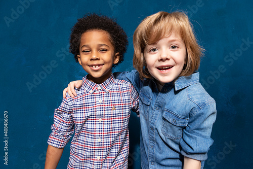 Portrait of two happy laughing multiracial friends schoolboys. Multiethnic friendship of two kids, joyful black african american embracing caucasian boy in tolerance unity, anti racism concept. photo