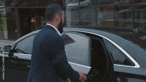 Wallpaper Mural Handheld footage of male driver opening car door of posh black auto and successful business-like brunette getting out of backseat Torontodigital.ca