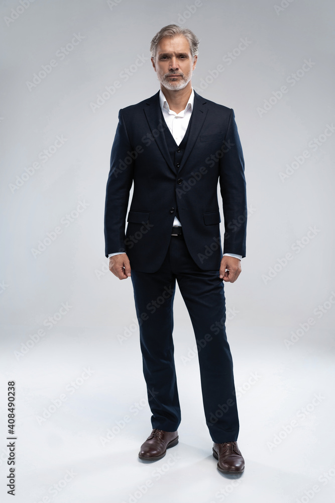 Full length shot of a mature businessman wearing a suit looking at camera - obrazy, fototapety, plakaty 