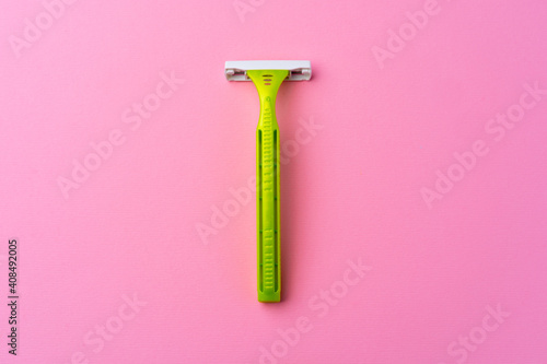 Single disposable razor on pink background top view photo