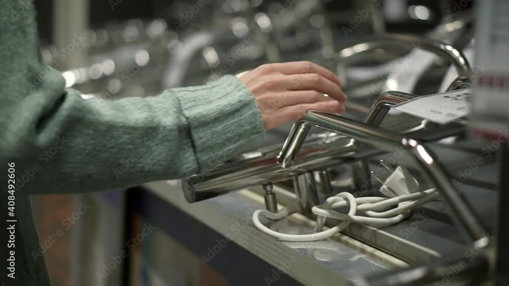 Woman is choosing a new furniture for bathroom in hardware store Woman is choosing a new furniture for bathroom in hardware store