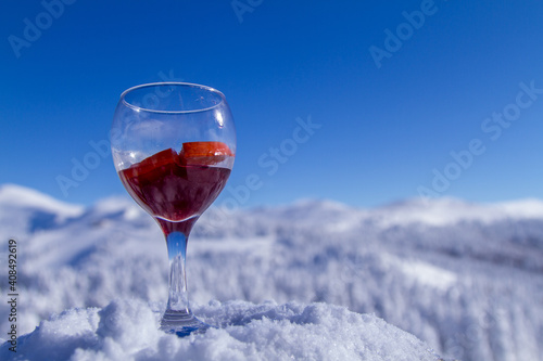 glass of red wine on snow