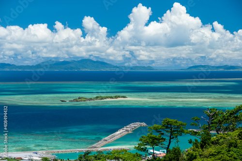 Fototapeta Naklejka Na Ścianę i Meble -  Port of Uehara surrounded by the beautiful turquoise blue sea and Ishigaki island on background seen from the road to Mount Uehara.