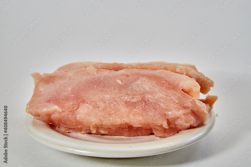 Raw chicken meat on plate on white background Raw chicken meat on plate on white background
