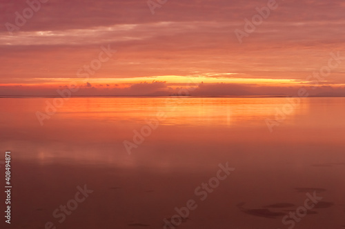 Long exposure of a radiant sunrise with a pink yellow colors reflected in the smooth surface of ocean at Nakano beach. Iriomote island. © Renata Barbarino