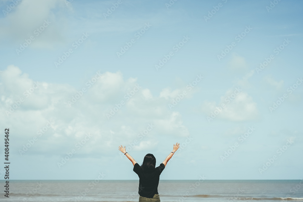 Happy woman raise hand up at tropical beach with blue sky background. Travel vacation and freedom feel good concept. Happy woman raise hand up at tropical beach with blue sky background. Travel vacation and freedom feel good concept.