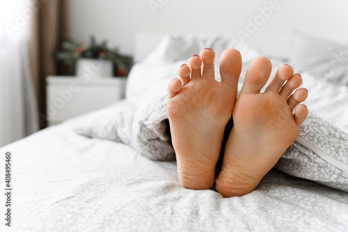 beautiful legs in bed. sexy legs of a girl lying in bed. feet under the blanket. skin problems on the legs. dermatology. family in bed. wonderful morning at home.feet in bed