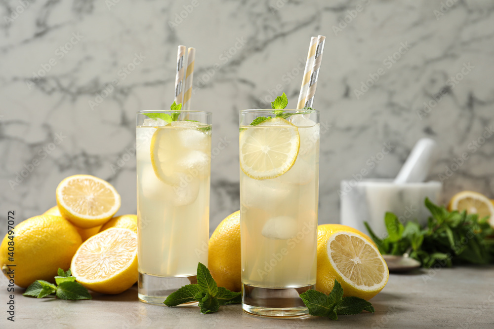 Natural lemonade with mint and fresh fruits on light grey table. Summer refreshing drink Natural lemonade with mint and fresh fruits on light grey table. Summer refreshing drink