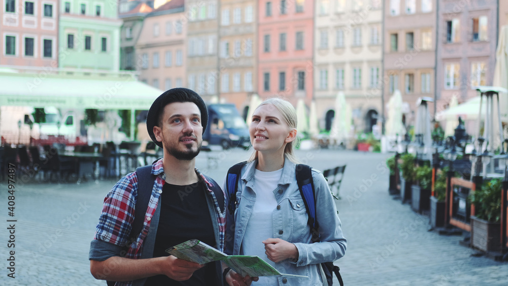 Fototapeta premium Happy couple of tourists looking on main tourist attractions using map. They are so happy to go sightseeing.