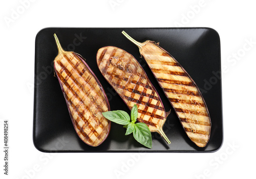 Delicious grilled eggplant halves with basil isolated on white, top view