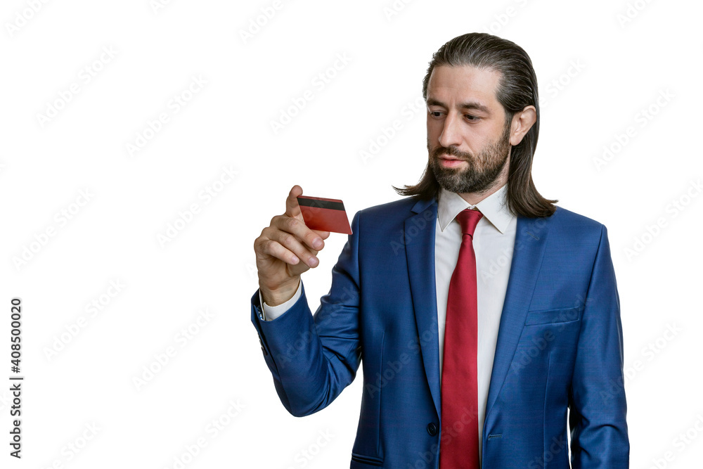 Charismatic businessman with a beard and long hair in a blue jacket and red tie with credit cards in his hand isolated on a white background. Portrait of an office worker. Charismatic businessman with a beard and long hair in a blue jacket and red tie with credit cards in his hand isolated on a white background. Portrait of an office worker.