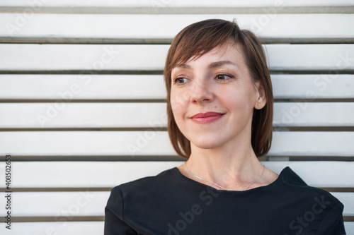 Portrait of a woman with short hair on a white wood background