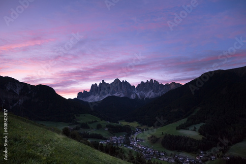 Sunrise over the small Italian mountain town of St. Magdalena in Val di Funes