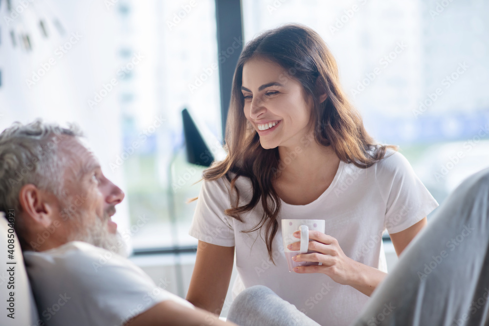 Happy woman with cup and man in profile Happy woman with cup and man in profile