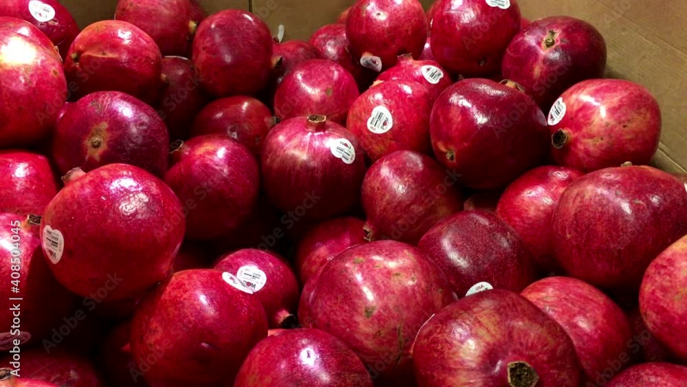 Woman selecting pomegranate in grocery store produce department with 4k resolution. Woman selecting pomegranate in grocery store produce department with 4k resolution.