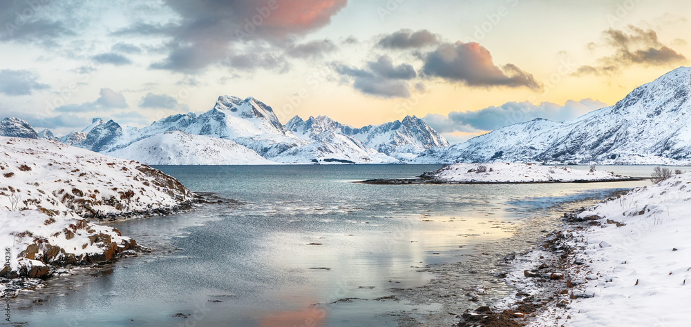 Stunning morning view of Torsfjorden fjord with cracked ice and snowy mountain peaks at background. Stunning morning view of Torsfjorden fjord with cracked ice and snowy mountain peaks at background.
