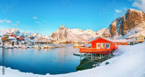 Gorgeous winter view on Hamnoy village with port and Festhaeltinden and Olstinden peaks on background