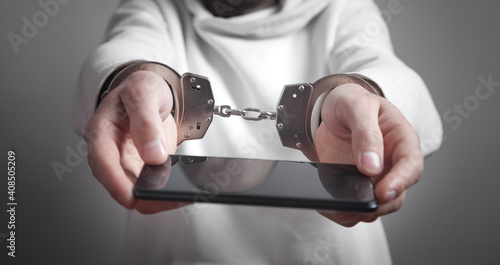 Man hands handcuffs holding smartphone. Internet and Social Media addiction