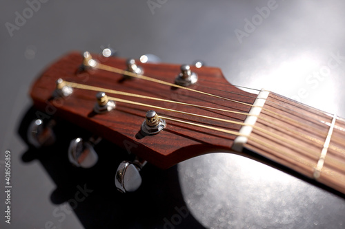 music and musical instruments concept - close up of acoustic guitar head with pegs © Syda Productions