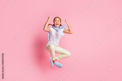 Full size photo of hooray girl fists up wear white t-shirt sweater trousers sneakers isolated on pink background