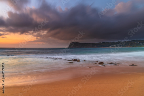 Sunrise at the seaside with rain clouds rolling in