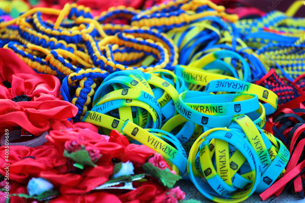 Ukrainian souvenirs in national blue and yellow colors at street market in Kyiv, Ukraine. Bracelets with word Ukraine in English and Ukrainian languages.