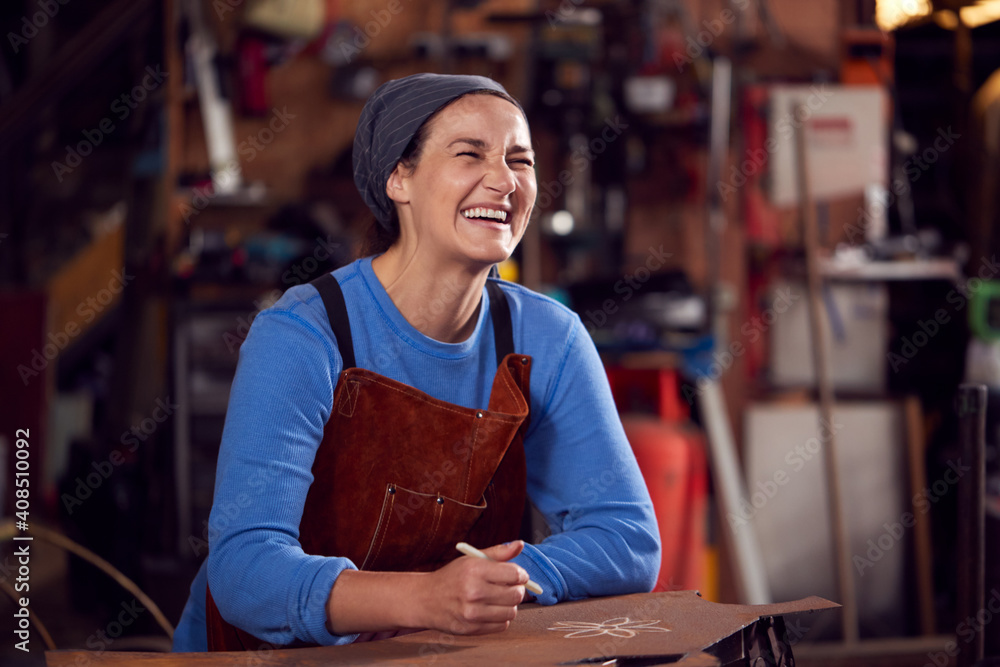 Obraz premium Female Blacksmith Wearing Headscarf Working On Design In Forge