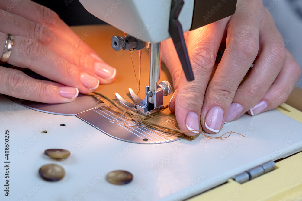 Woman sews on a sewing machine. Woman sews on a sewing machine.