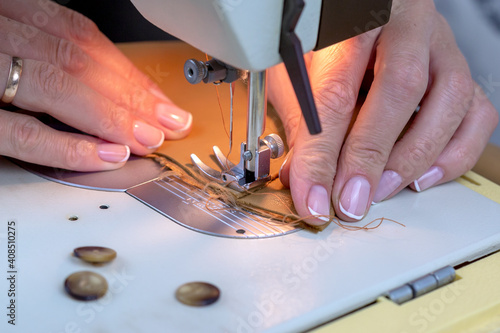 Woman sews on a sewing machine.