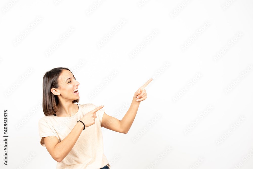 Pretty smiling hispanic girl pointing to white copy space whith two hands Pretty smiling hispanic girl pointing to white copy space whith two hands