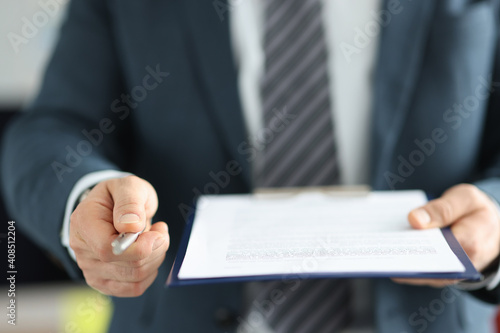 Businessman giving ballpoint pen to sign document closeup