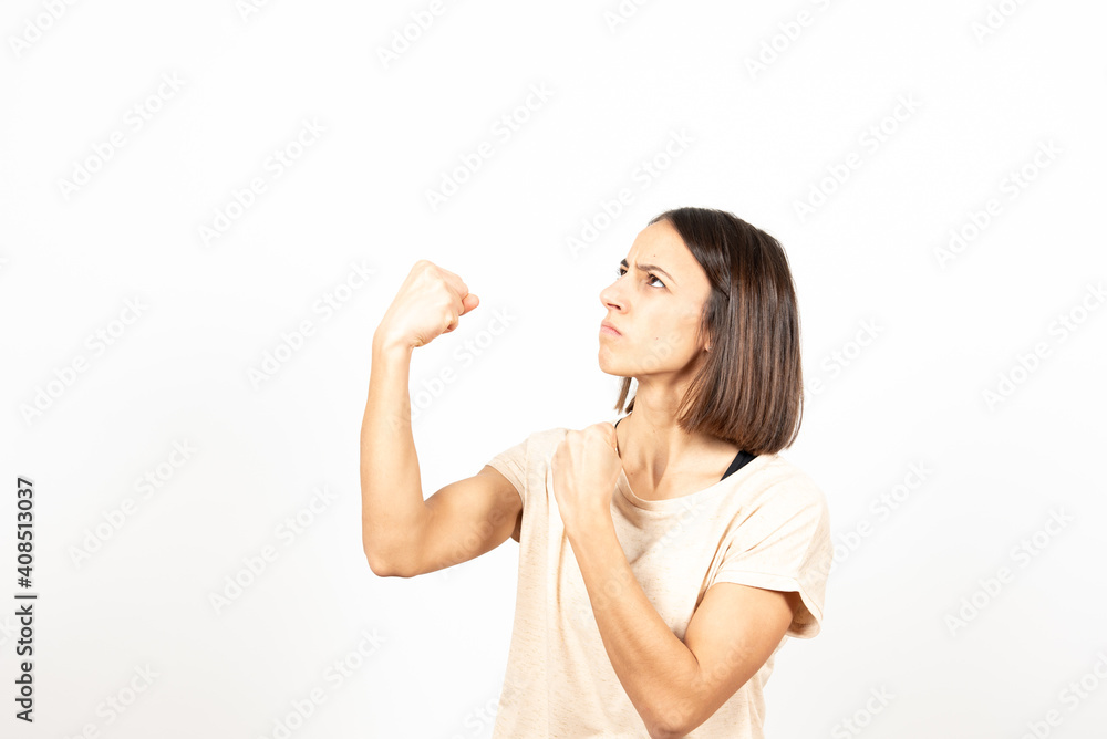 An angry young woman in fighting position looking to the copy space. An angry young woman in fighting position looking to the copy space.