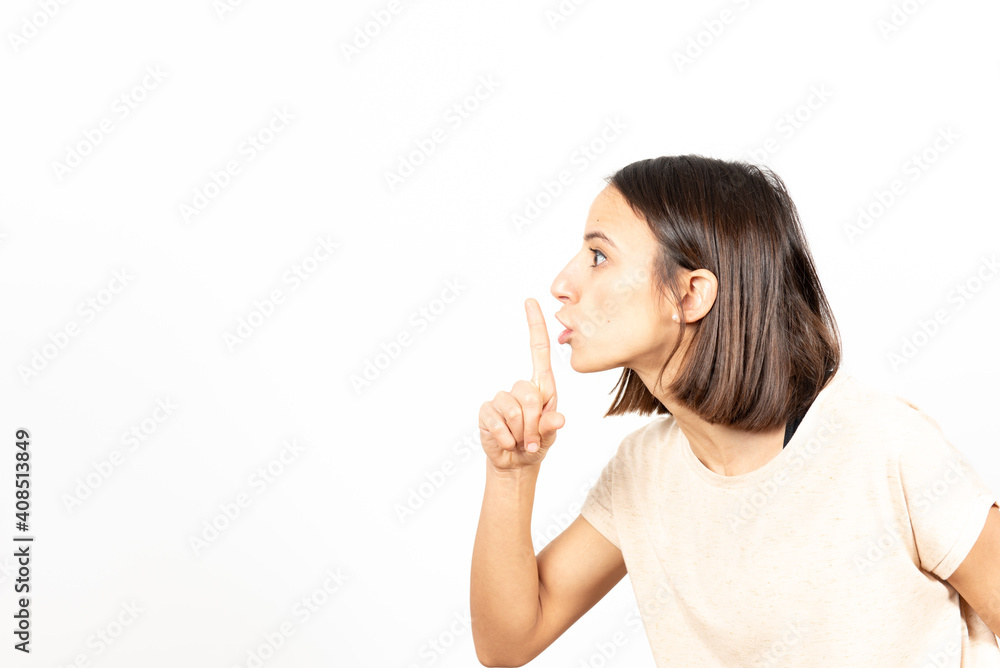 Side view of a latin woman asking for silence with the finger on her mouth. Side view of a latin woman asking for silence with the finger on her mouth.