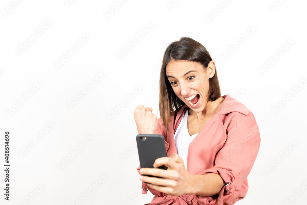Happy latin woman celebrating the good news or results while looking at her cell phone. Happy latin woman celebrating the good news or results while looking at her cell phone.