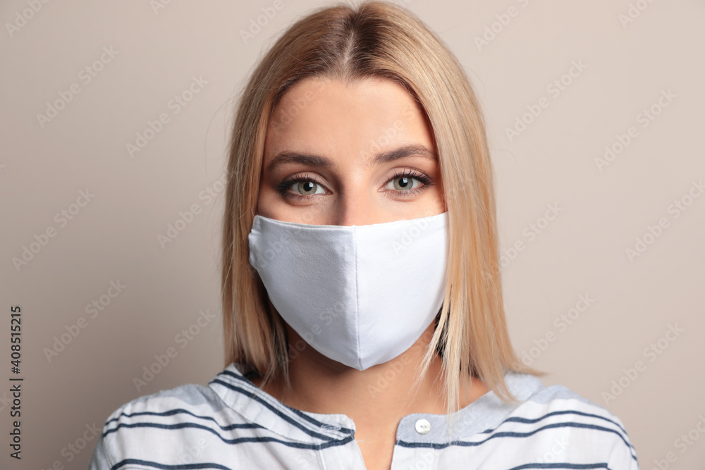 Young woman in protective face mask on beige background Young woman in protective face mask on beige background