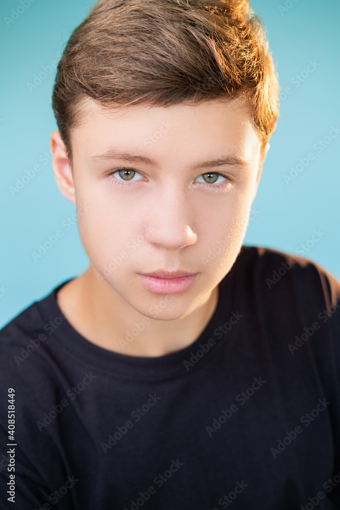 Confident guy. Teen lifestyle. Independence inspiration. Closeup portrait of ambitious boy in black t-shirt looking at camera isolated on blue background. Confident guy. Teen lifestyle. Independence inspiration. Closeup portrait of ambitious boy in black t-shirt looking at camera isolated on blue background.