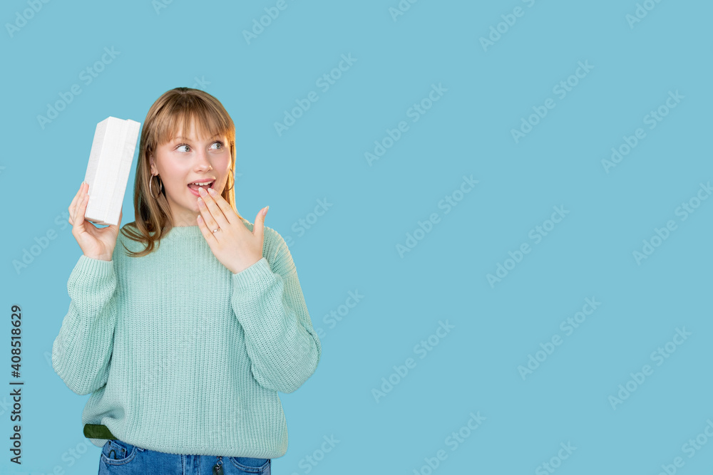 Festive surprise. Holiday shopping. Sale discount. Portrait of curious amused excited woman wondering present in white gift box isolated on blue empty space promotional background. Festive surprise. Holiday shopping. Sale discount. Portrait of curious amused excited woman wondering present in white gift box isolated on blue empty space promotional background.