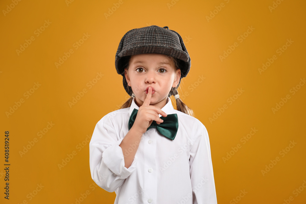 Cute little detective in hat on yellow background Cute little detective in hat on yellow background