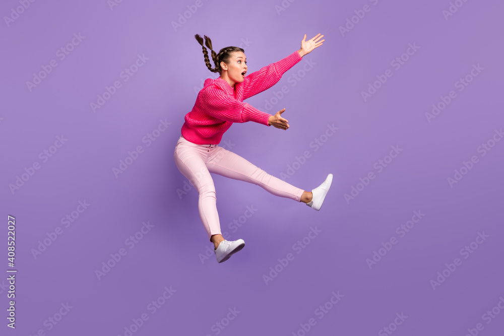 Full size profile side photo of young attractive beautiful girl jumping look copyspace catching isolated on purple color background Full size profile side photo of young attractive beautiful girl jumping look copyspace catching isolated on purple color background