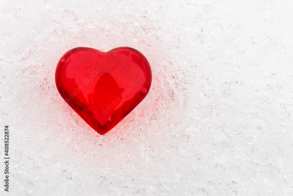 Little red heart in the snow (valentine's day greeting card, selective focus)